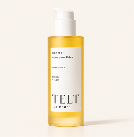 A bottle of Telt Skincare Body Melt in a clear cylindrical bottle showing the golden-yellow oil inside, with a white pump dispenser and a white label on a light beige background.
